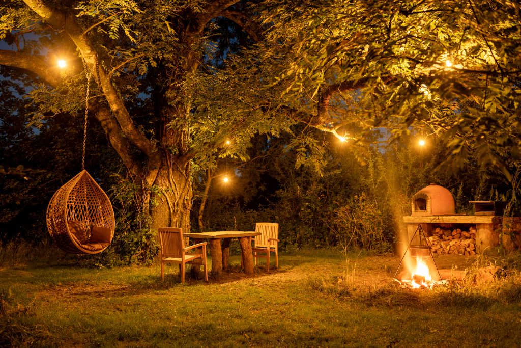 firepit, picnic table and swing under fairylights