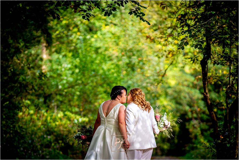 Nature's Embrace: Couple framed by the natural archway of Bryngarw House's garden