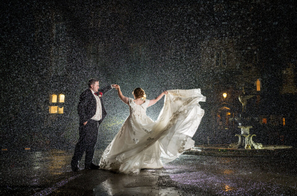 Bride and Groom dancing in the rain outside Craig Y Nos Castle
